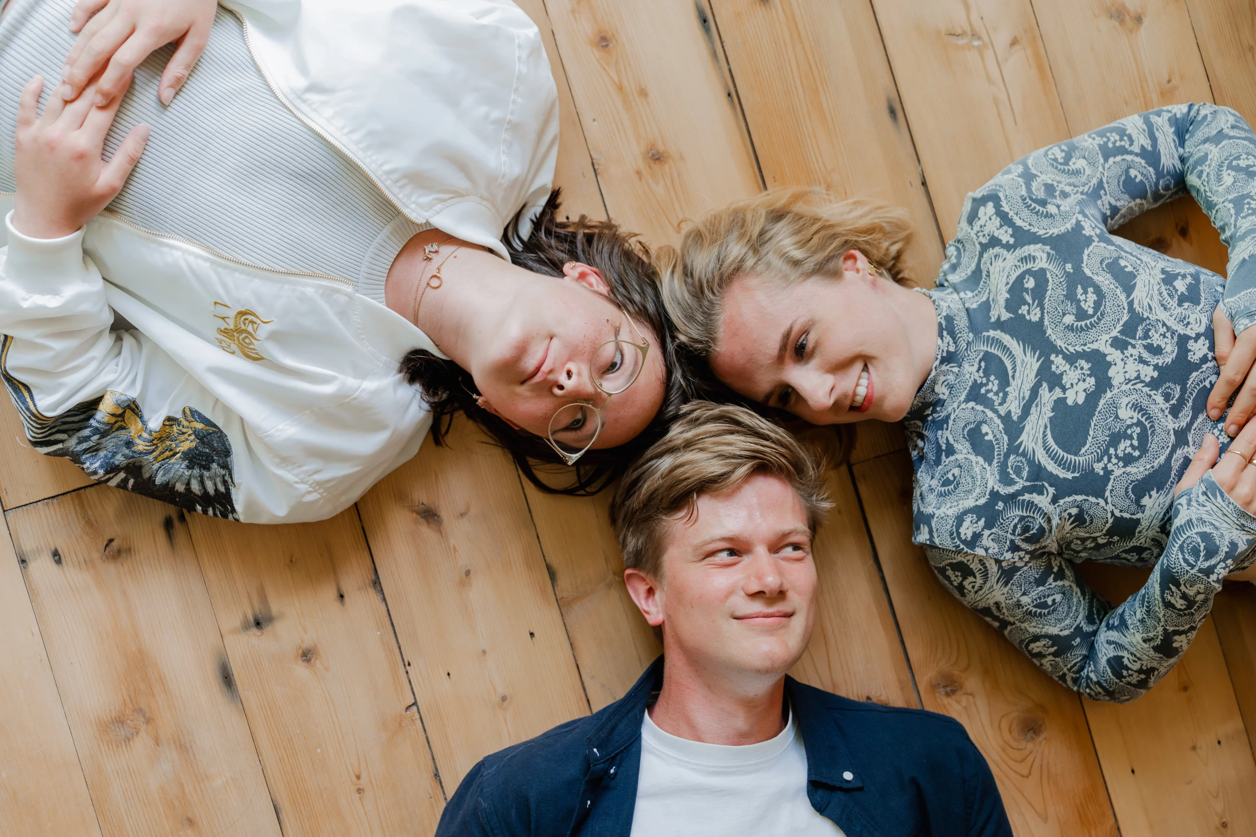 Jongeren liggen op de grond en kijken omhoog